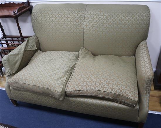 An upholstered sofa on tapered square mahogany legs with brass caps and castors. W.140cm